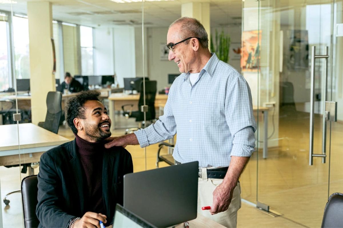 When Pressure Wears a Smile: Emotional Manipulation at Work Boss speaking with employee at his desk, symbolising subtle emotional pressure in professional settings.