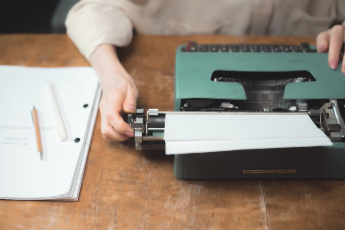 Vintage typewriter with pen and paper on a desk, symbolising writing as emotional release and purpose in old age.