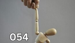 A wooden mannequin being controlled by a hand, symbolising emotional manipulation and loss of self-control.