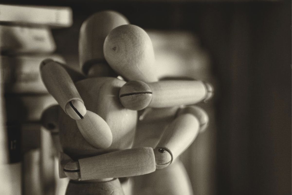 Wooden Mannequins Embracing: The Hidden Tension in Manipulative Relationships Two wooden mannequins embracing, symbolising emotionally complex or controlling relationships.