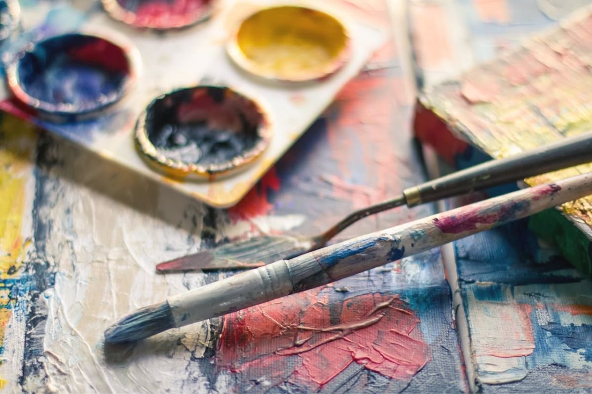Paintbrush and colourful pallet symbolising painting as a joyful hobby that lifts the spirit.