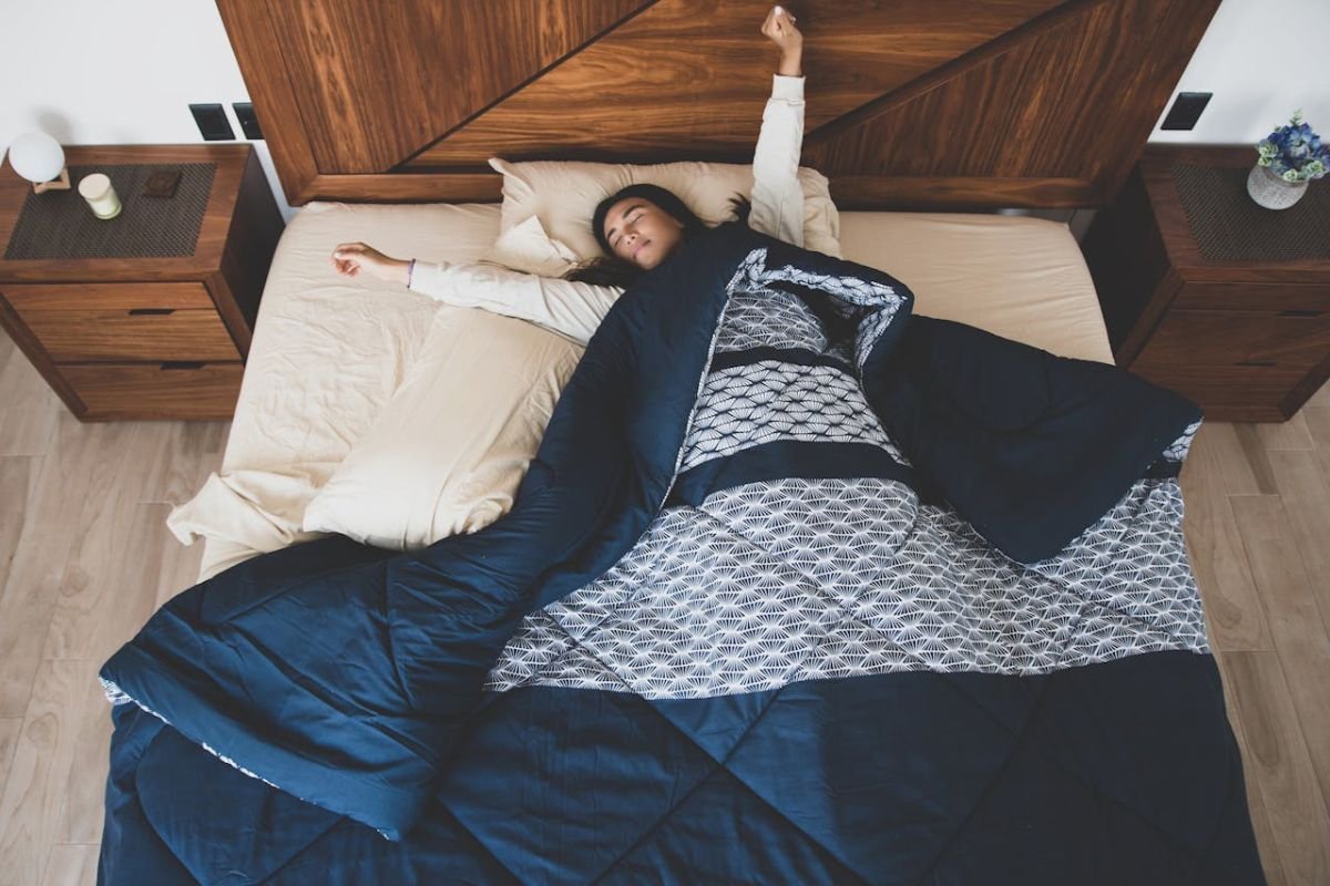Woman waking up refreshed after a good night’s sleep, showing the benefits of keeping a steady sleep routine.