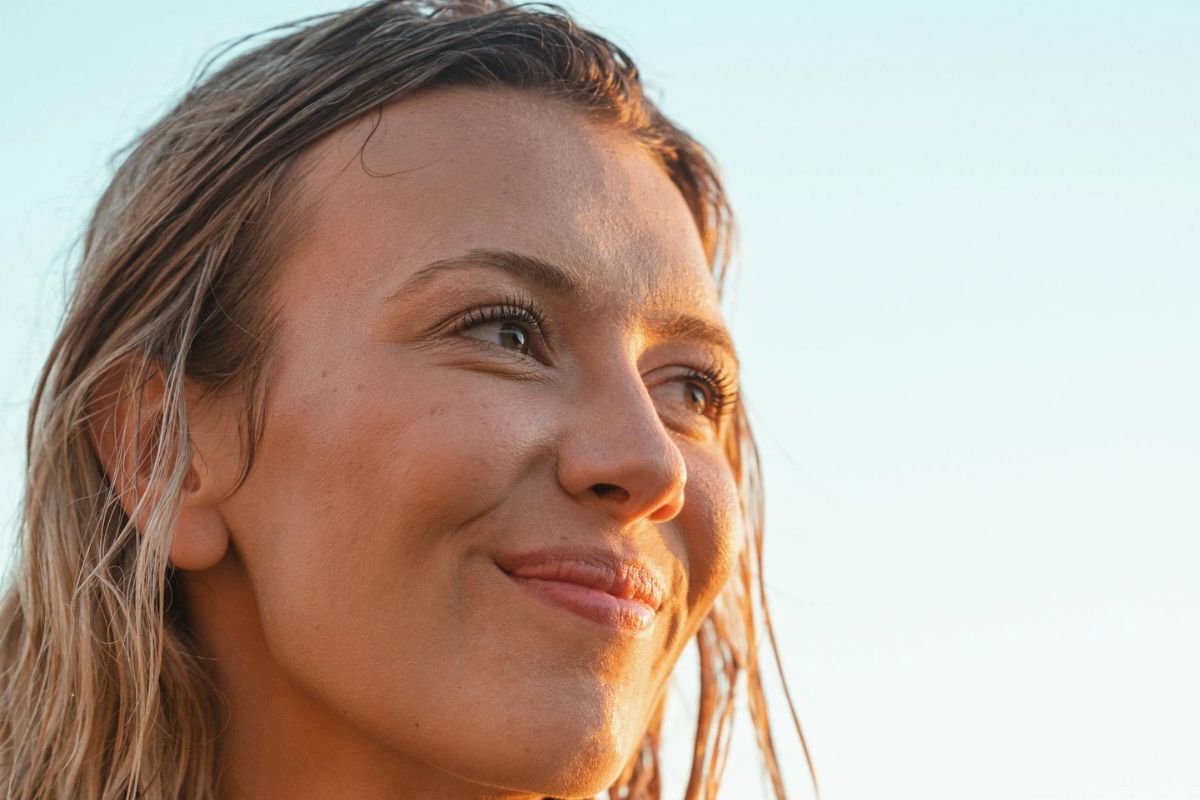 Smiling woman with glowing skin, relaxed and healthy