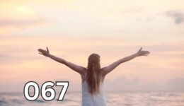 Rear view of a woman standing alone at the beach during sunset with arms raised, symbolising independence and inner peace in later life.
