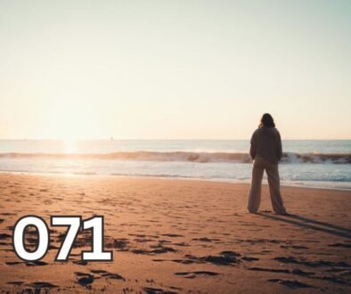 Woman standing alone on beach at sunset, silhouette by calm sea