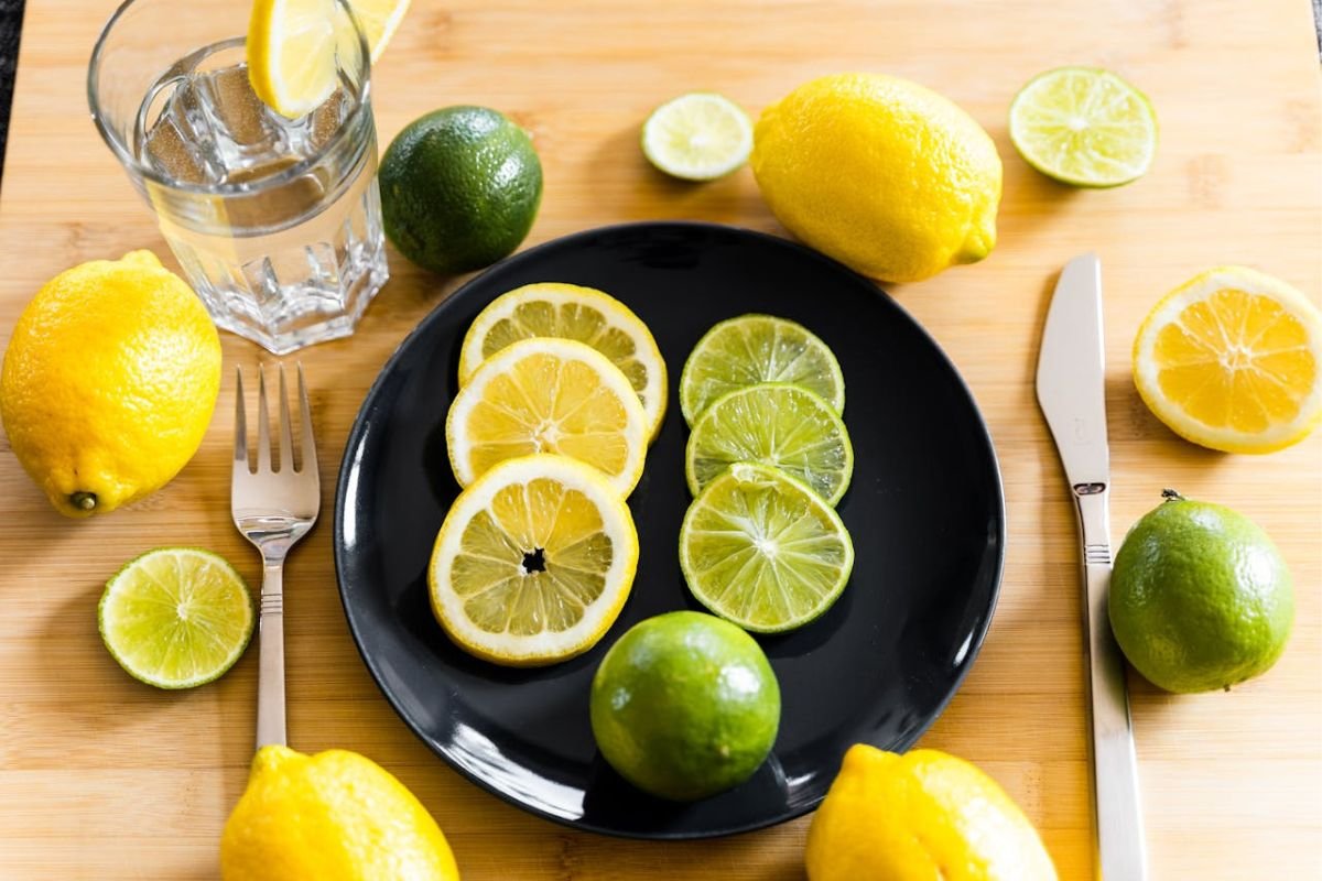 Lemons and limes on a table with a glass of water