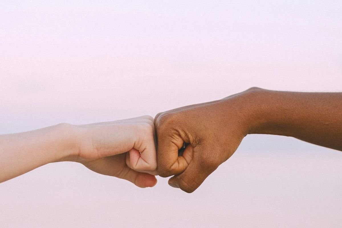 Two hands meeting in a fist bump, symbolising compassion, understanding, and emotional support for someone coping with OCD or anxiety.