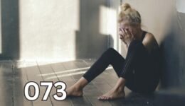 Woman sitting on floor covering her face, heartbroken and reflective