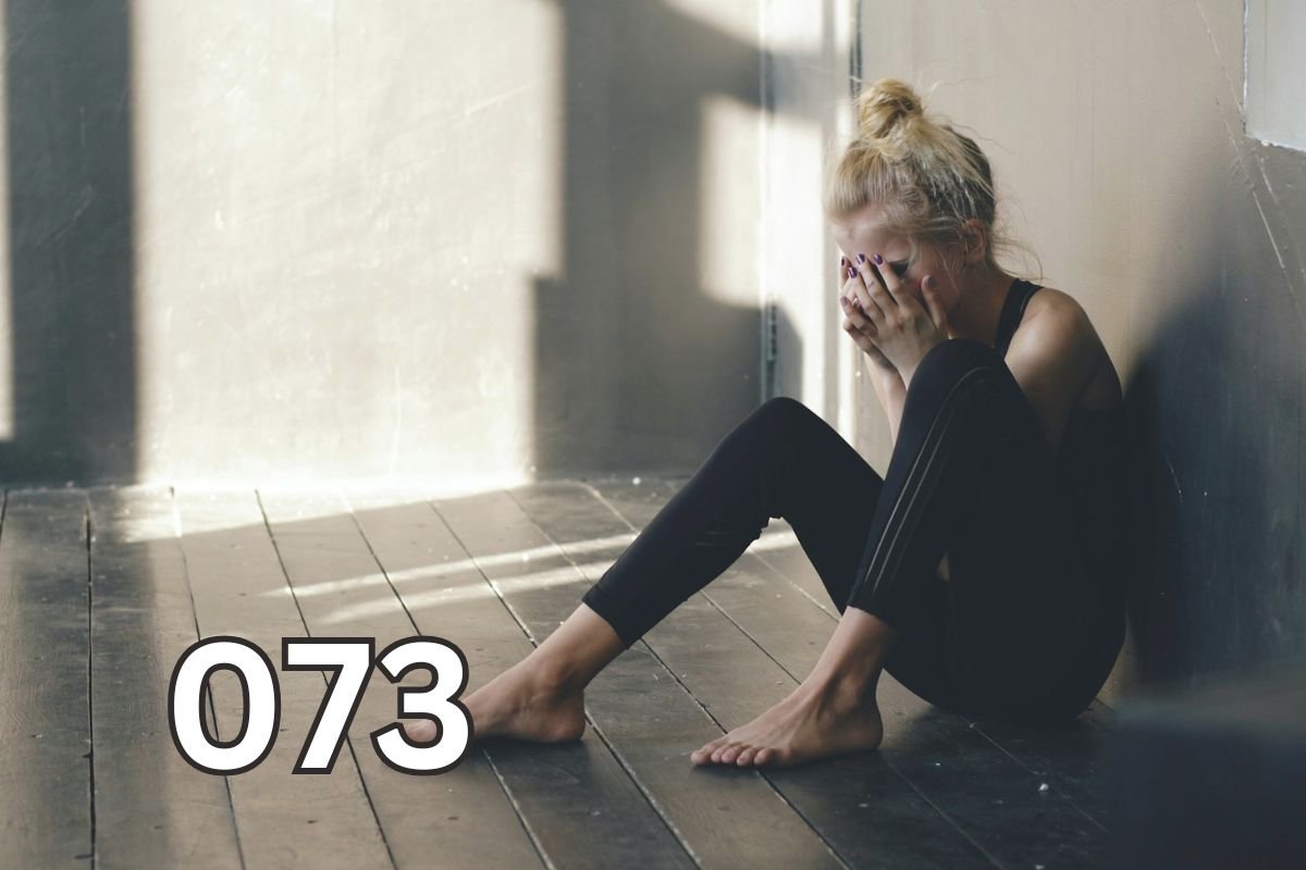 Woman sitting on floor covering her face, heartbroken and reflective