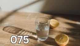 Clear glass of water with lemon slices on wooden surface