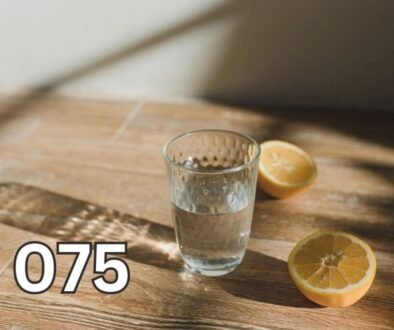 Clear glass of water with lemon slices on wooden surface