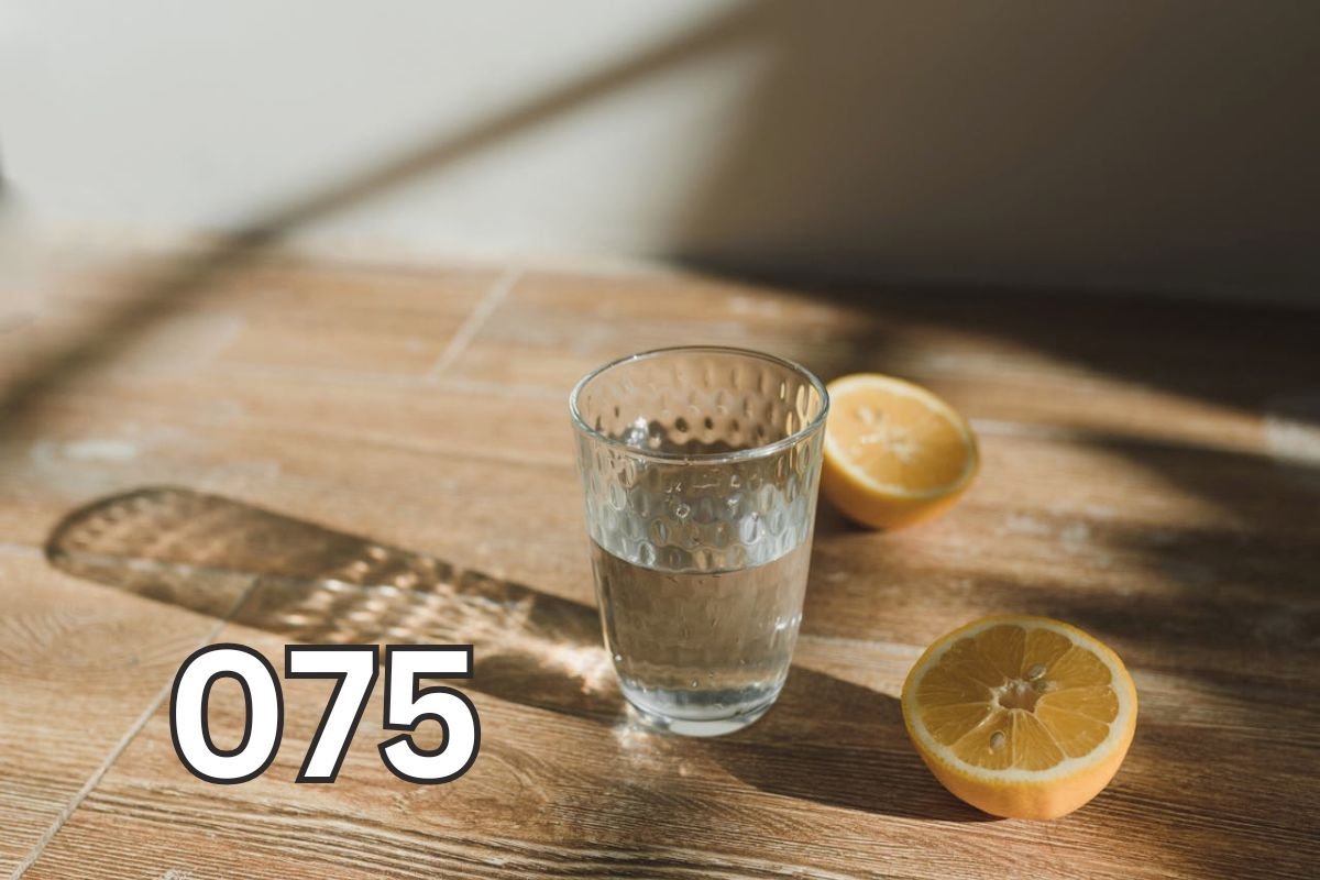 Clear glass of water with lemon slices on wooden surface