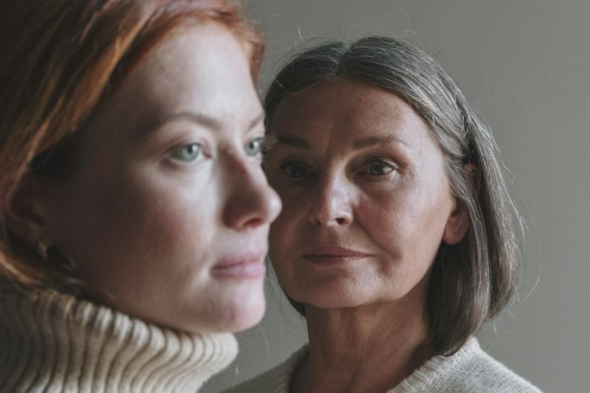 An elderly mother and adult daughter sharing a tender moment, reflecting thoughtful communication and understanding between generations.