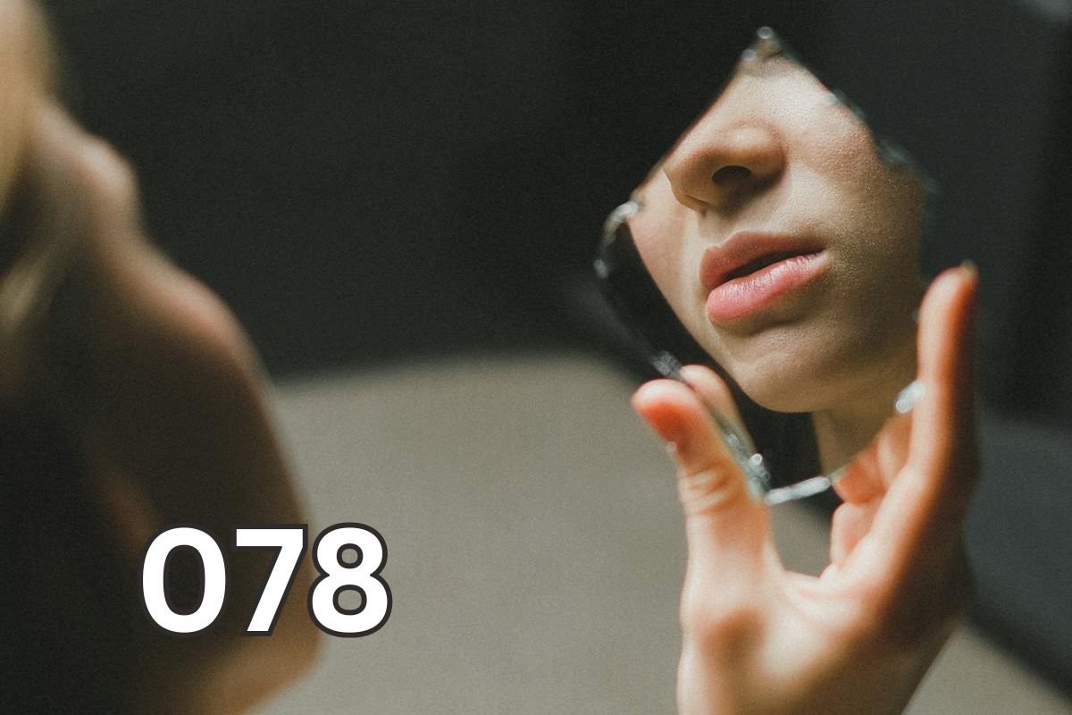 A person holding a broken mirror fragment showing only part of their face, symbolising how silent abuse quietly fractures a relationship.