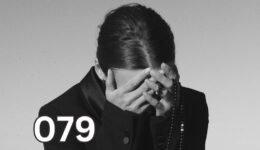 A woman covering her face in distress, symbolising emotional overwhelm and PTSD symptoms following trauma.