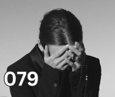 A woman covering her face in distress, symbolising emotional overwhelm and PTSD symptoms following trauma.