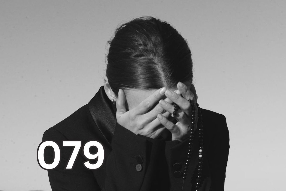 A woman covering her face in distress, symbolising emotional overwhelm and PTSD symptoms following trauma.