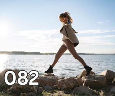 Woman balancing across coastal rocks alone, symbolising personal growth through lived experience and life lessons learned without advice.