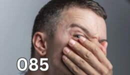 Man covering his nose and mouth with his hand looking uncomfortable, illustrating embarrassment from bad breath