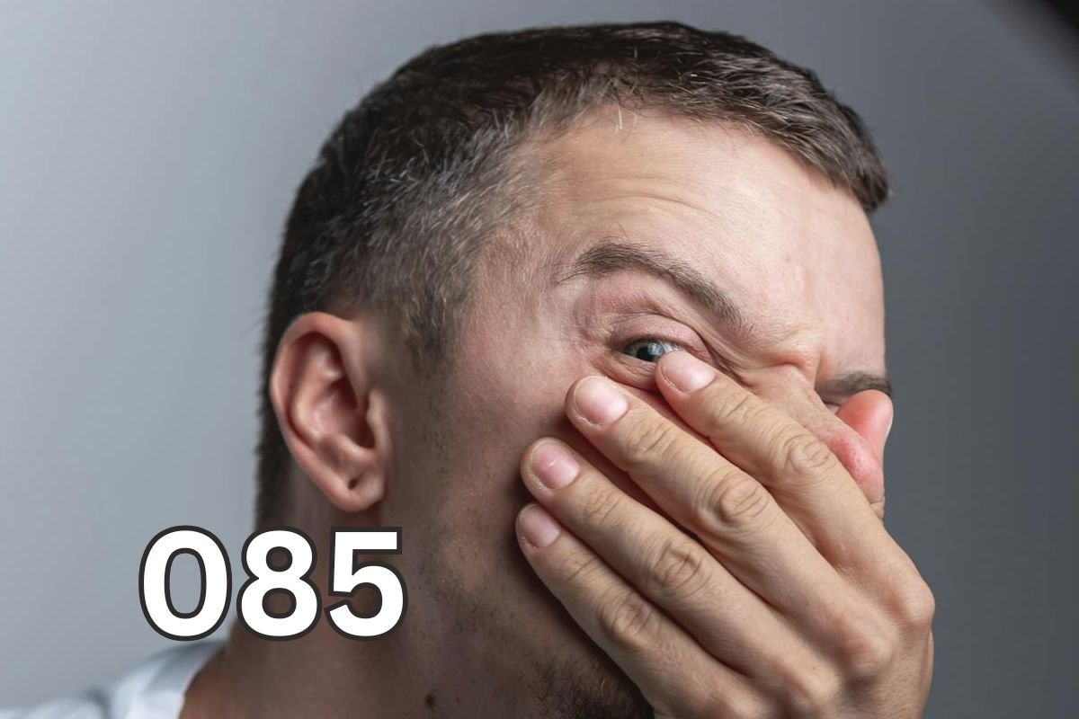 Man covering his nose and mouth with his hand looking uncomfortable, illustrating embarrassment from bad breath