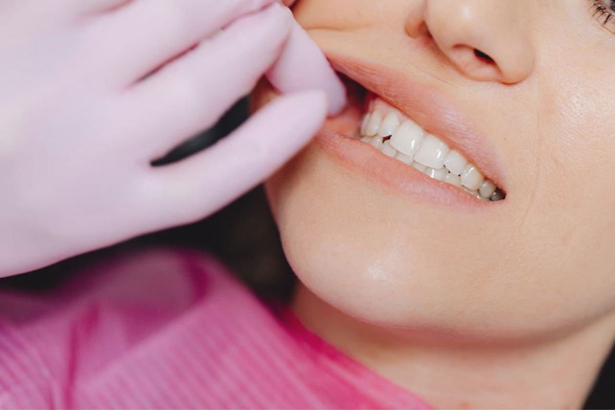 Dentist examining woman's teeth with latex gloves to check oral hygiene and dental health
