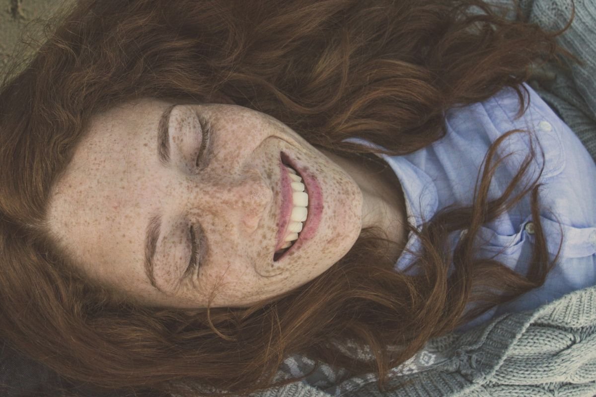 Woman smiling brightly with visible teeth, expressing confidence and fresh breath after good oral habits