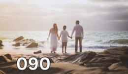 Parents holding their child’s hands while walking together on a beach, symbolising emotional support, healthy parenting, and family connection.
