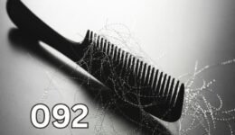 Black comb with strands of shed hair illustrating hair loss causes, thinning hair, and overall scalp and health concerns.
