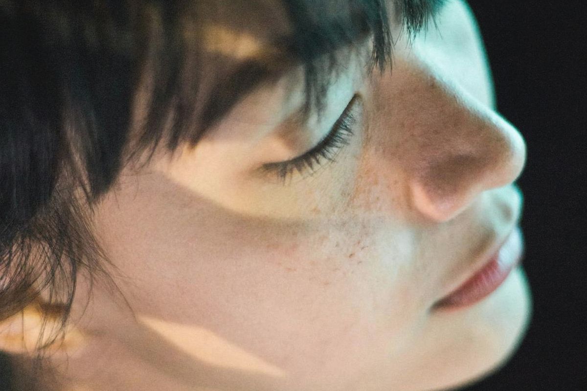 Woman with closed eyes symbolising aphantasia, memory recall differences, and the experience of remembering without mental imagery.