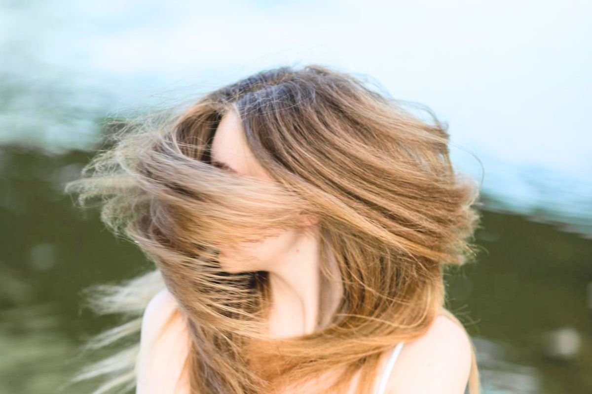 Woman with long healthy hair illustrating healthy scalp habits, strong hair growth, and overall hair and scalp wellness.