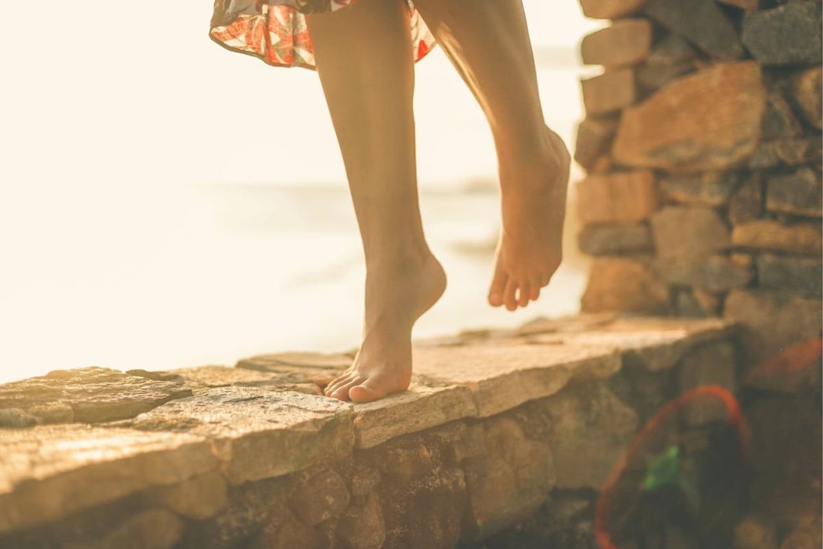 Close-up of barefoot walking on stone path, symbolising gentle healing, balance, and zinc supporting gut health and recovery.