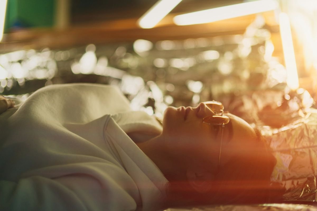 Woman lying on bed looking fatigued, representing zinc deficiency symptoms, gut health struggles, and digestive imbalance.
