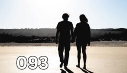 Couple holding hands while walking barefoot on a beach, symbolising growing old together and lifelong companionship.