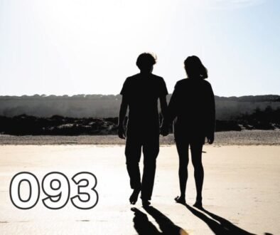 Couple holding hands while walking barefoot on a beach, symbolising growing old together and lifelong companionship.