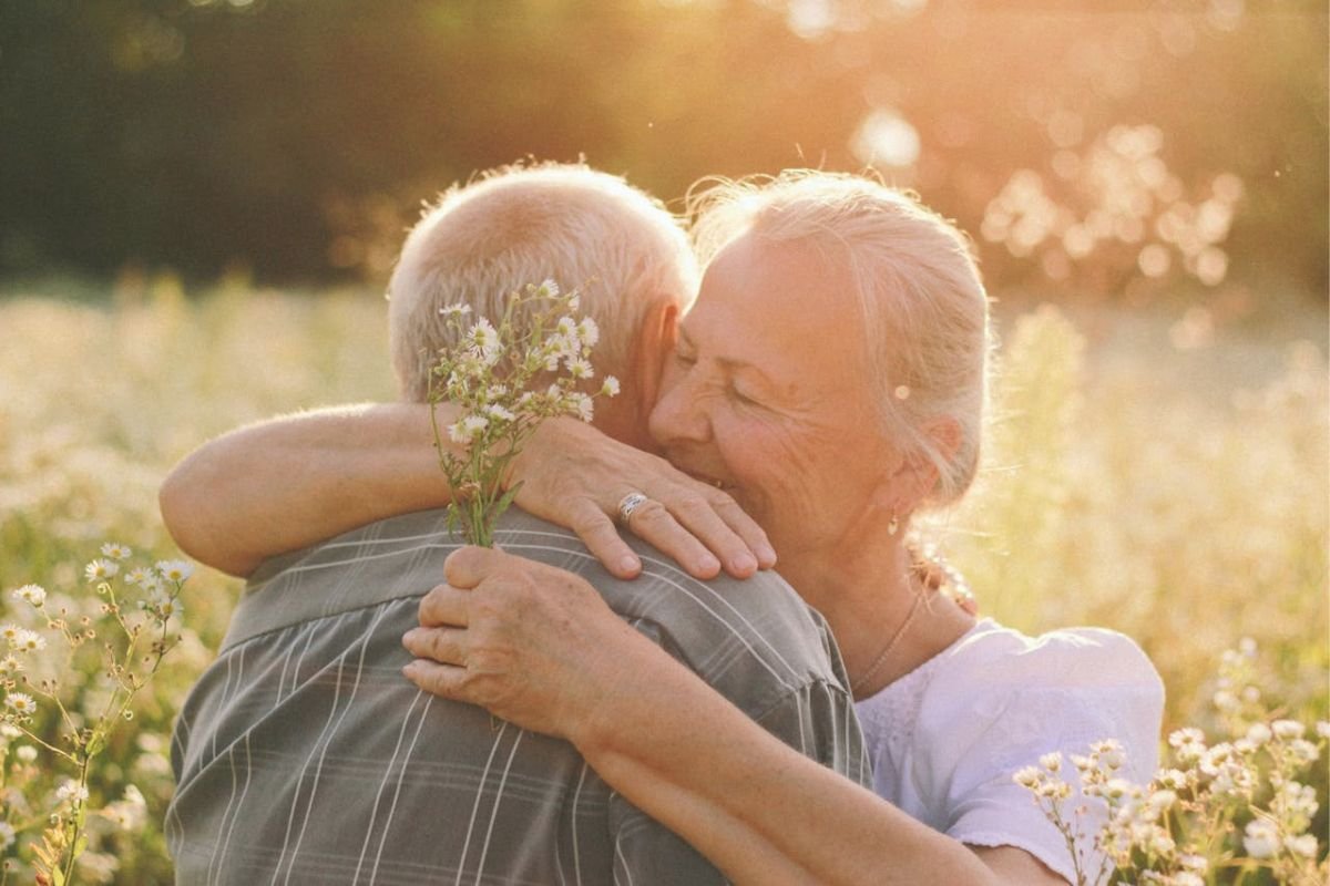 Elderly couple embracing outdoors, symbolising growing old together, lifelong companionship, and enduring love in later life.