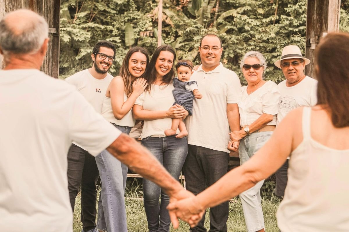 Multigenerational family holding hands outdoors, symbolising family harmony, support, and healthy relationships between generations.