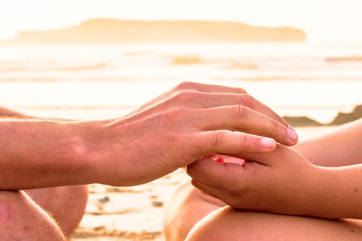 Adult holding a child's hand, symbolising inner child healing, re-parenting, emotional support, and healing childhood trauma.