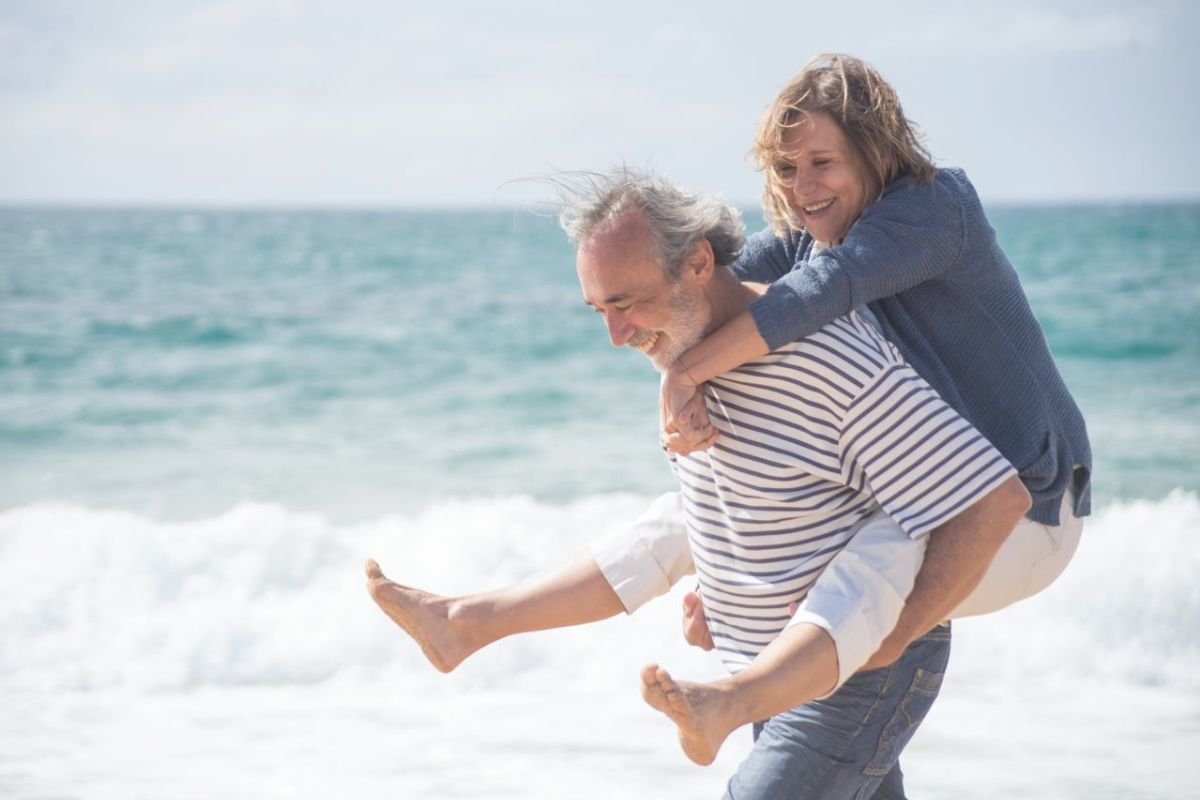 Ageing parents enjoying retirement together by the sea after raising adult children and embracing a fulfilling new chapter of life.