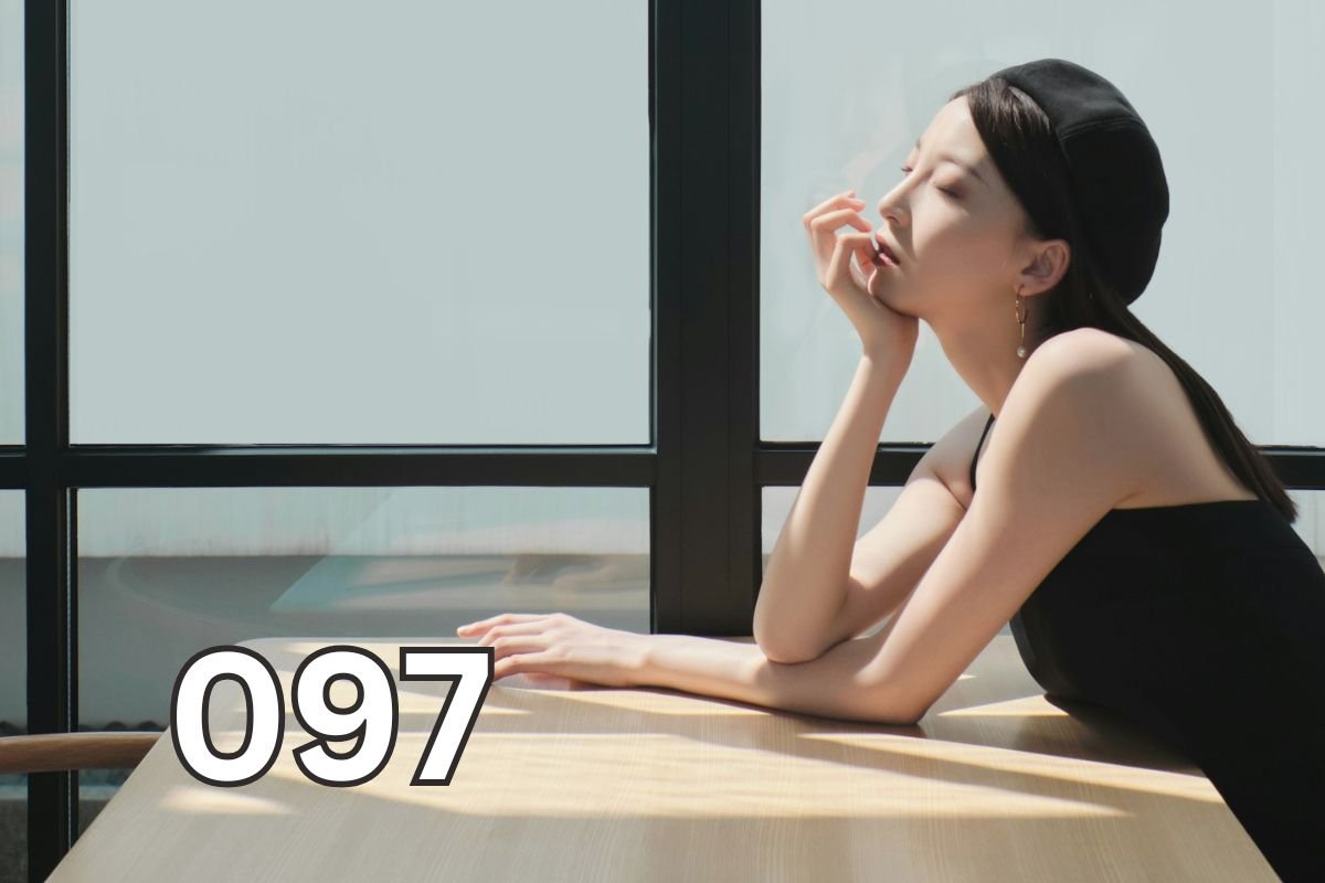Woman sitting beside a window with her eyes closed, reflecting quietly as an illustration for an article explaining depression and major depressive disorder.