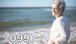 Smiling older woman standing on a beach, reflecting on life after losing a spouse and embracing hope for the future.
