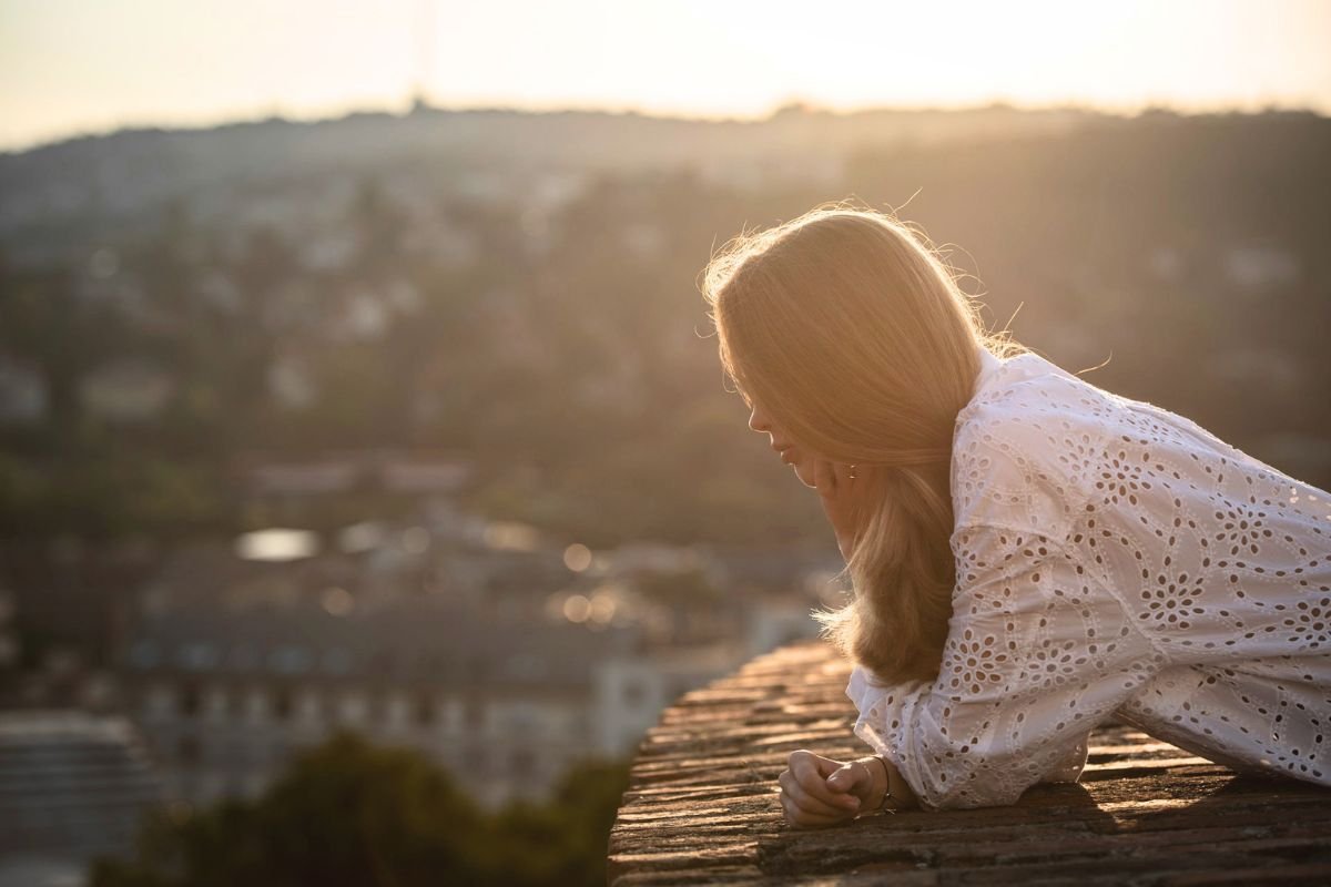 Woman overlooking a city at sunset, illustrating the different types of depression and the personal journey of emotional wellbeing.