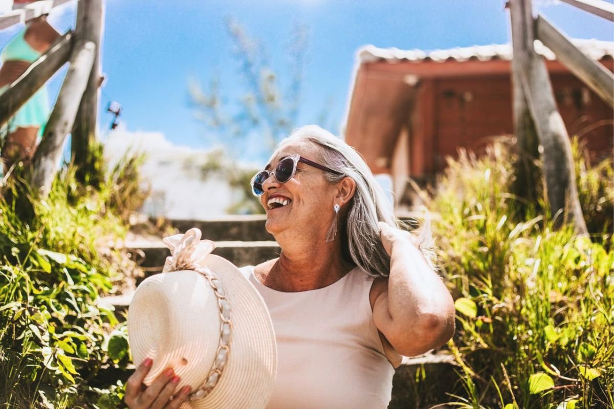 Happy older woman smiling confidently outdoors after rebuilding a meaningful life following the loss of a spouse.