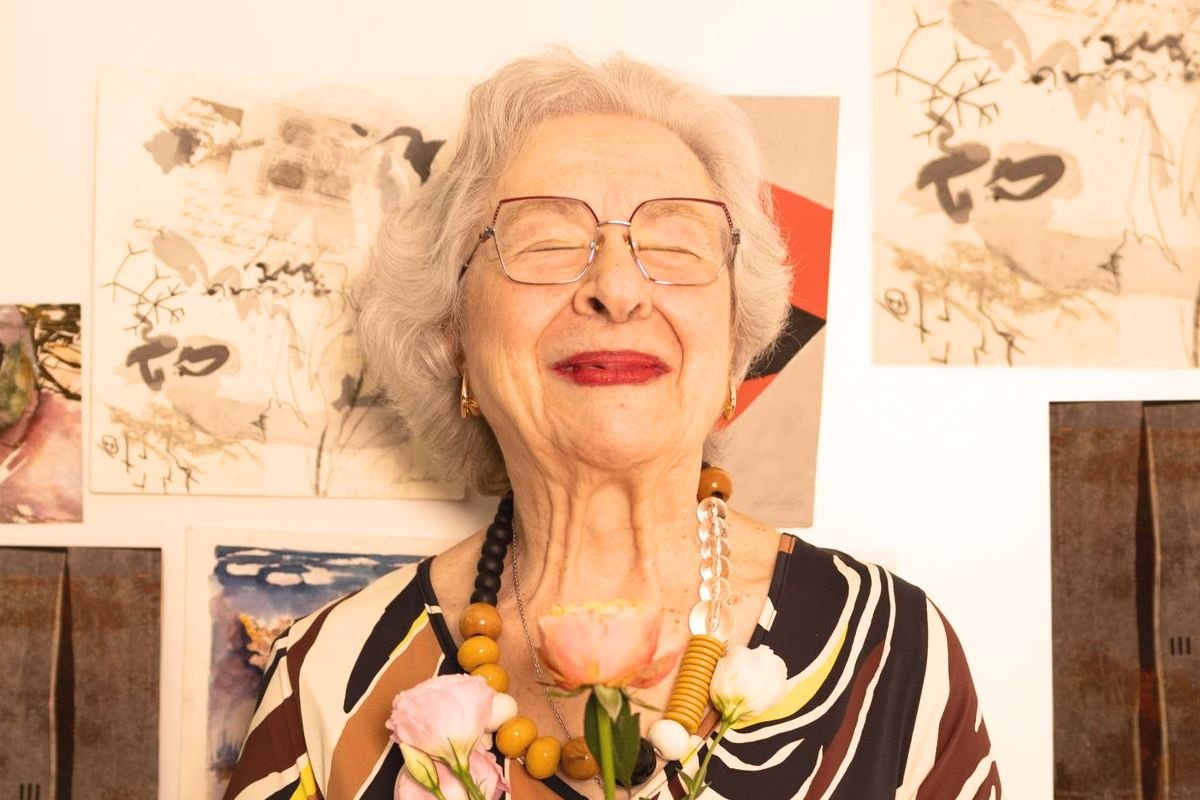 Smiling older woman holding flowers as she embraces a fresh chapter of life after losing a spouse.