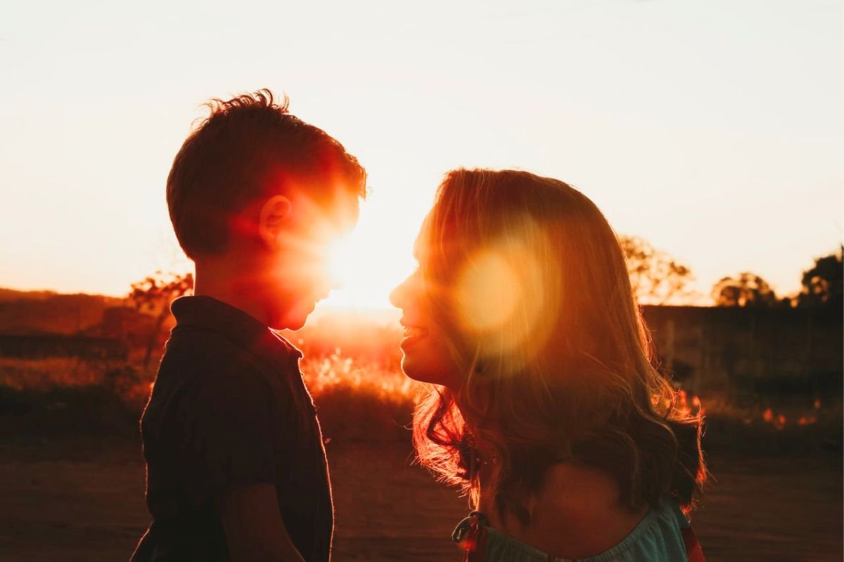 Mother and child sharing a warm smile at sunset, illustrating understanding, empathy, and positive parent-child connection.