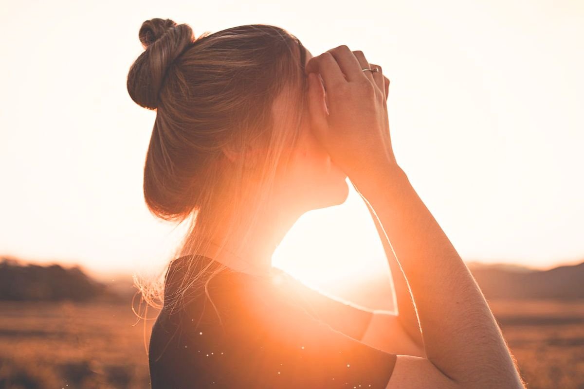 Woman standing in a field at sunset, symbolising hope, recovery from depression, emotional healing, and mental wellbeing.