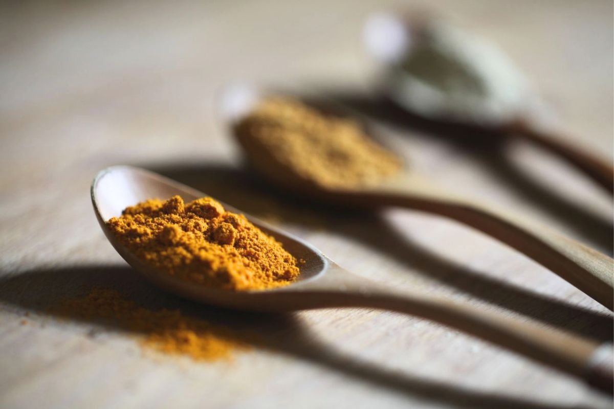 Spoon filled with turmeric powder, symbolising the everyday food choices that contribute to long-term health and wellbeing.
