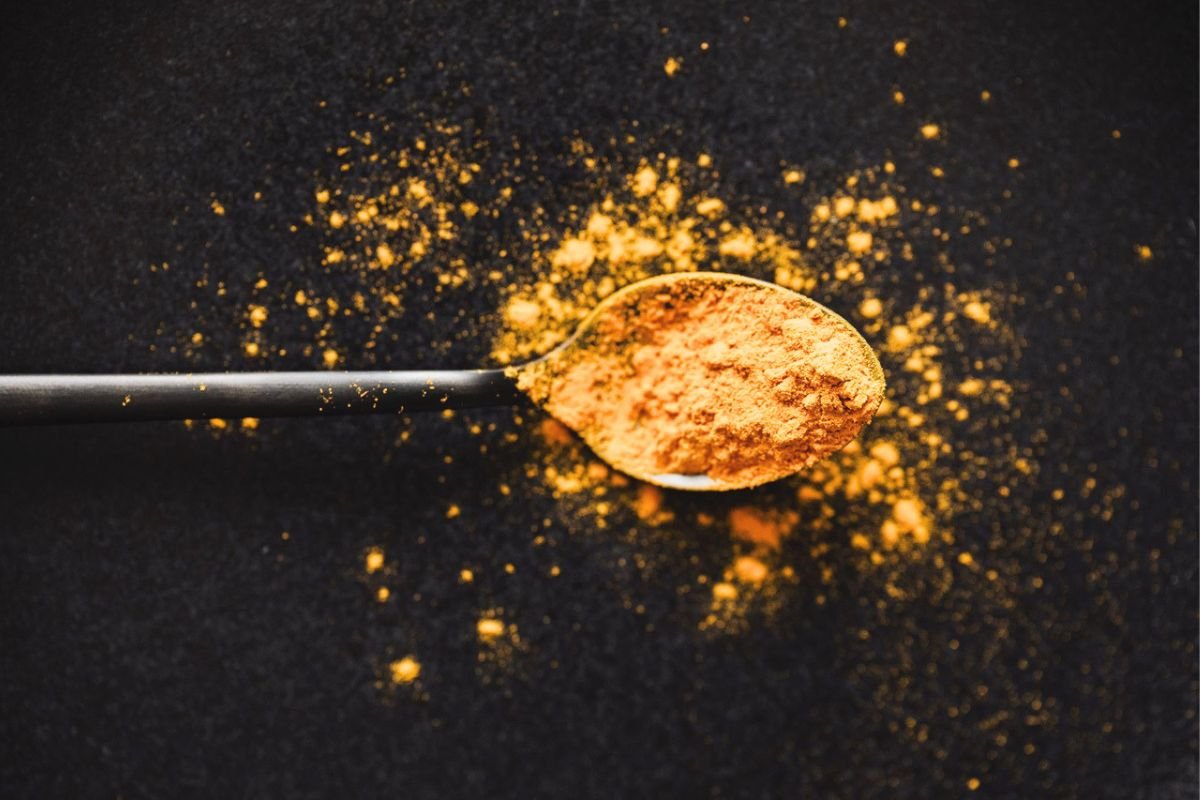 Turmeric powder on a spoon, illustrating curcumin research related to liver health, metabolic health, and healthy ageing.