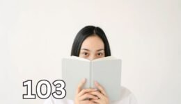 Woman covering her mouth with a book, representing the uncertainty and self-consciousness often associated with social anxiety vs introversion.