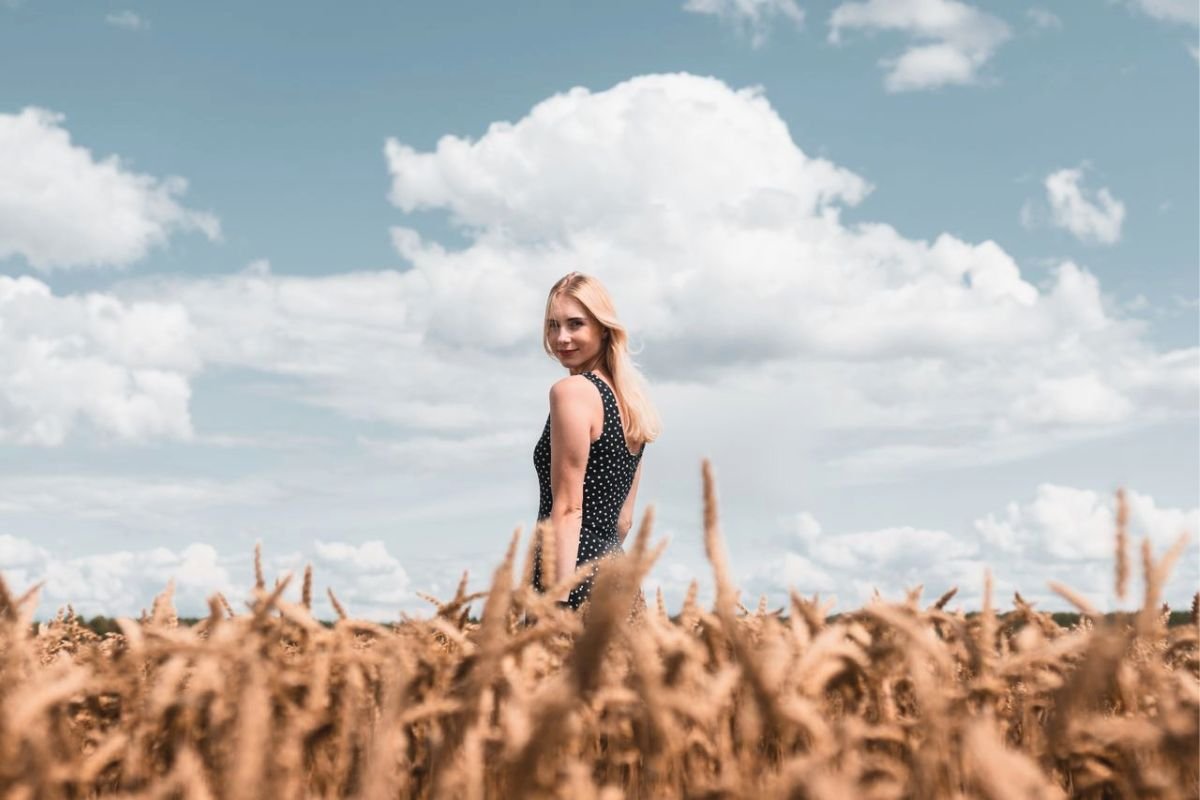 Confident woman standing in a grassy field, representing healthy boundaries, self respect, and the confidence to stop being taken advantage of.