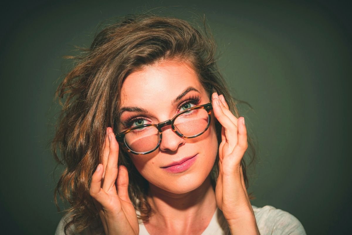 Woman adjusting her glasses in a close-up portrait